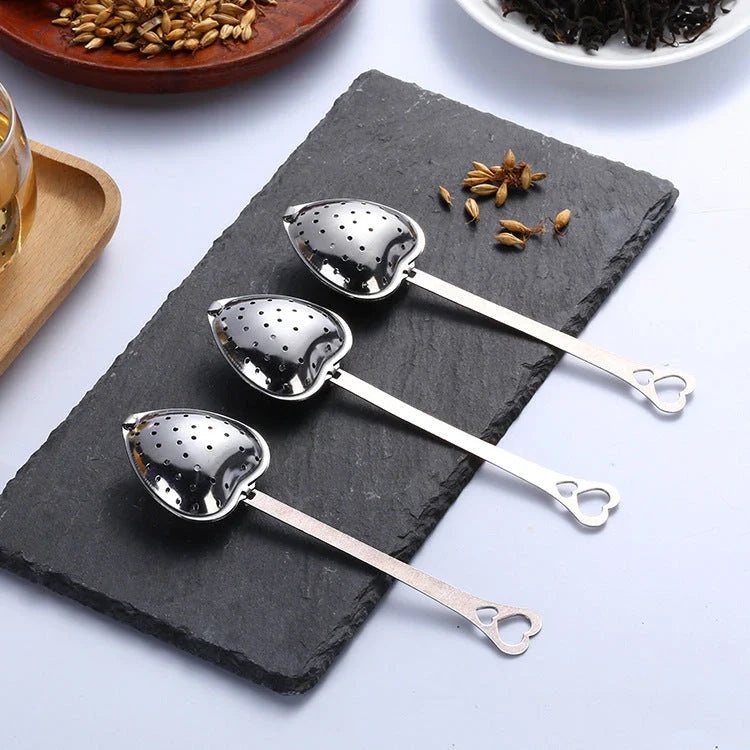 Heart-shaped stainless steel tea infuser with chain, perfect for steeping loose-leaf teas and spices