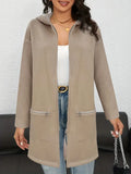 A woman wearing a loose grey mid-length cardigan coat with pockets, casual style.