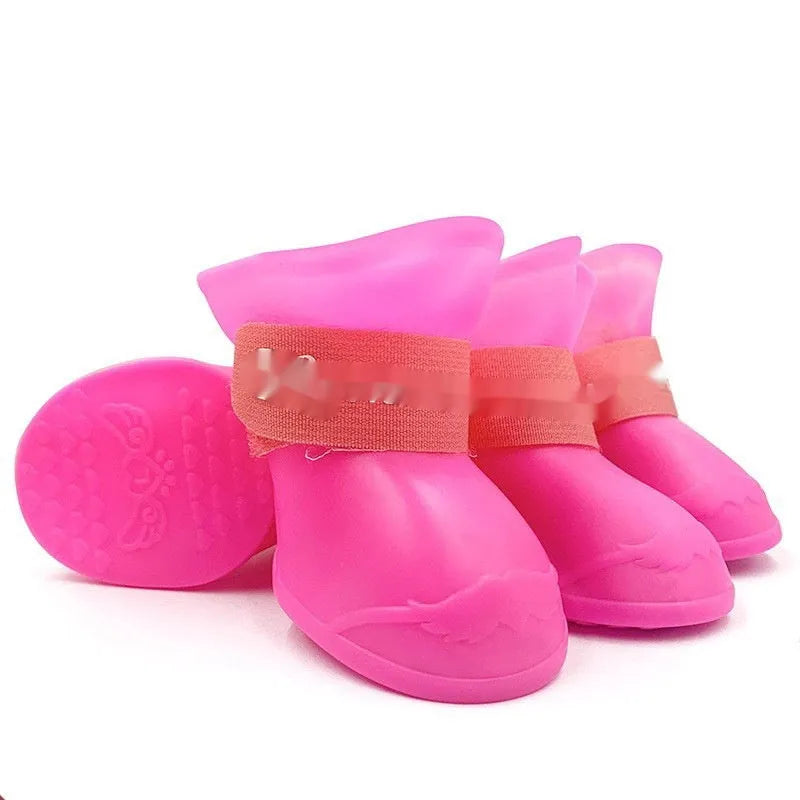 Four rubber pet rain shoes in various colours with anti-slip soles for dog paw protection