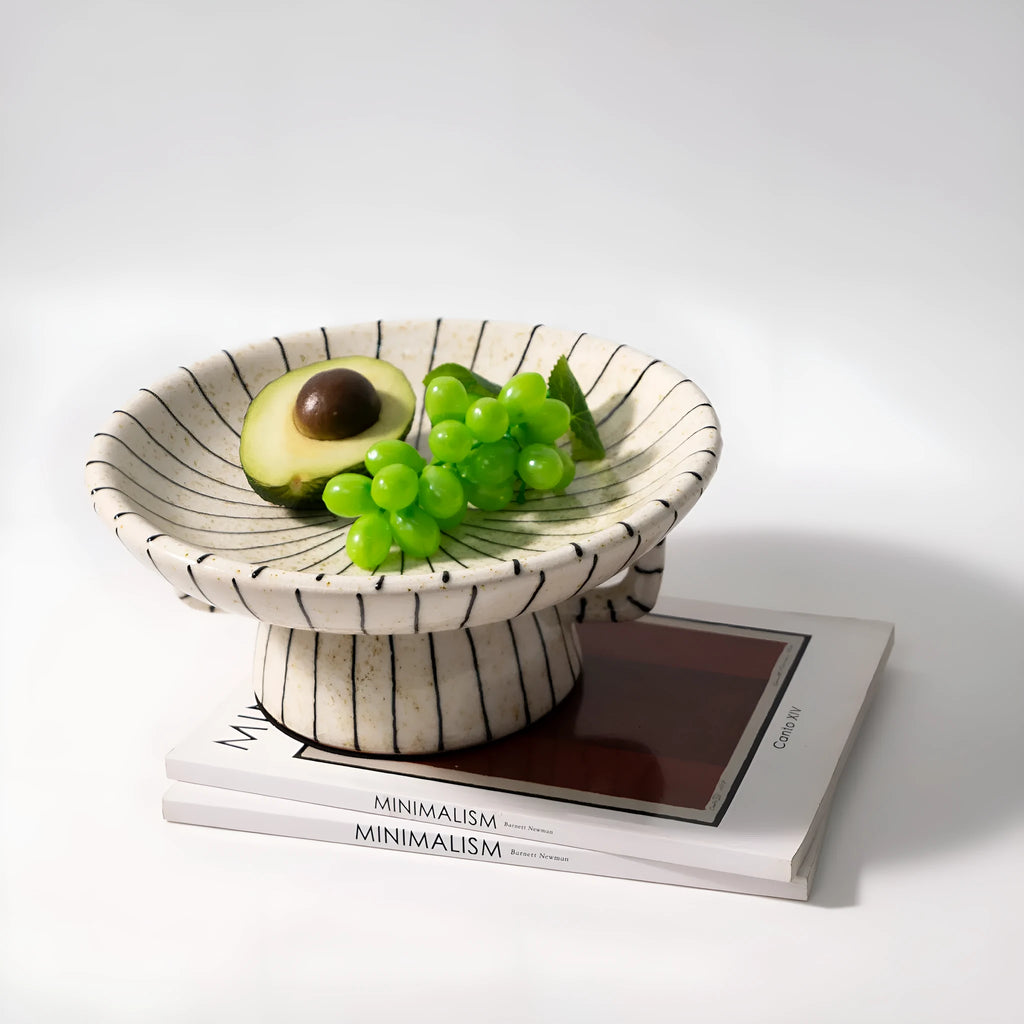 Black and white striped synthetic resin fruit plate on a plain surface.