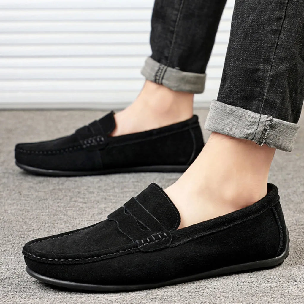 Men's brown suede slip-on loafers with round toe and flat rubber sole on a white background