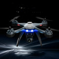 Plastic quadrocopter drone with remote controller, spare blades, and landing gear on a white background.