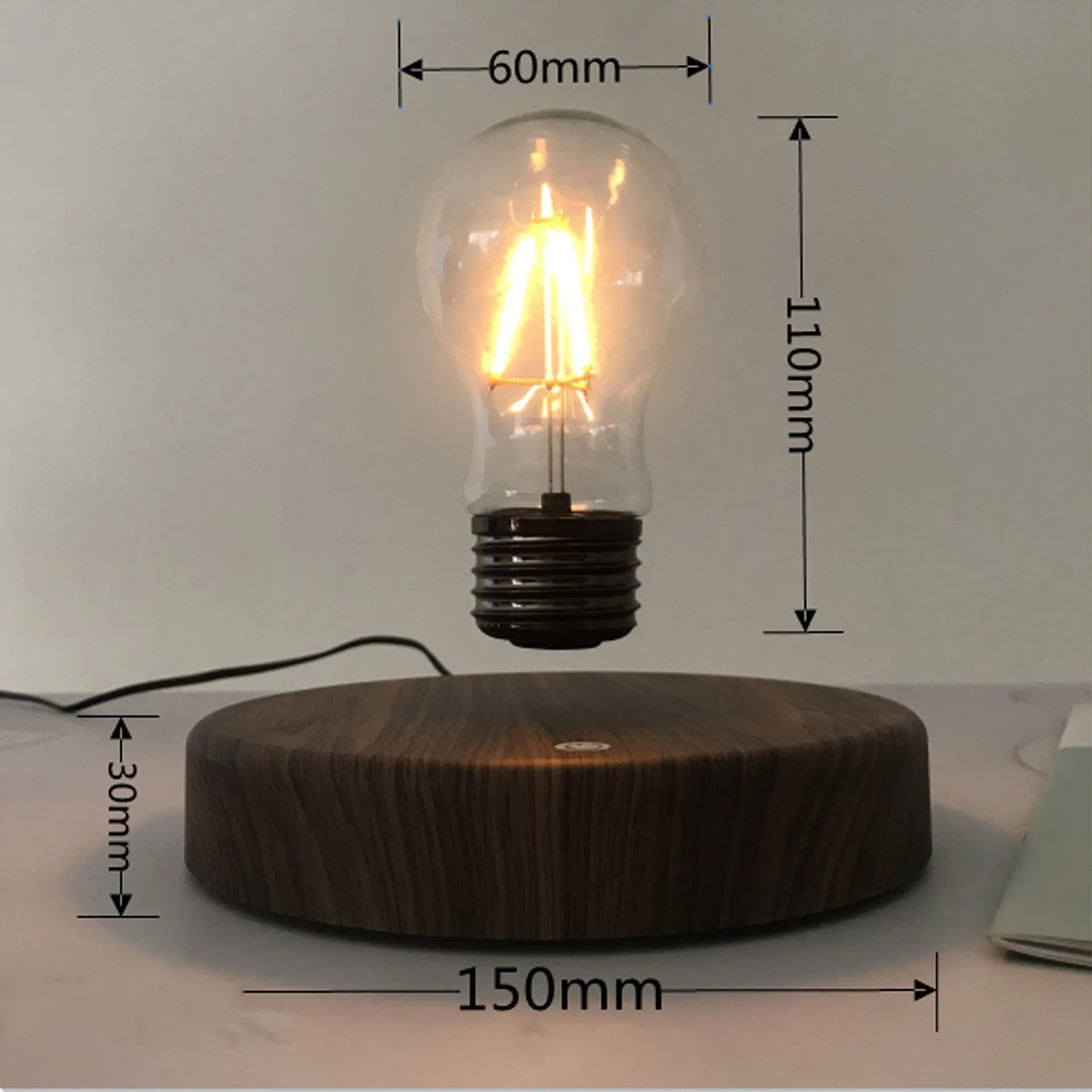 Magnetic levitation bulb night light in solid wood colour floating above desktop base