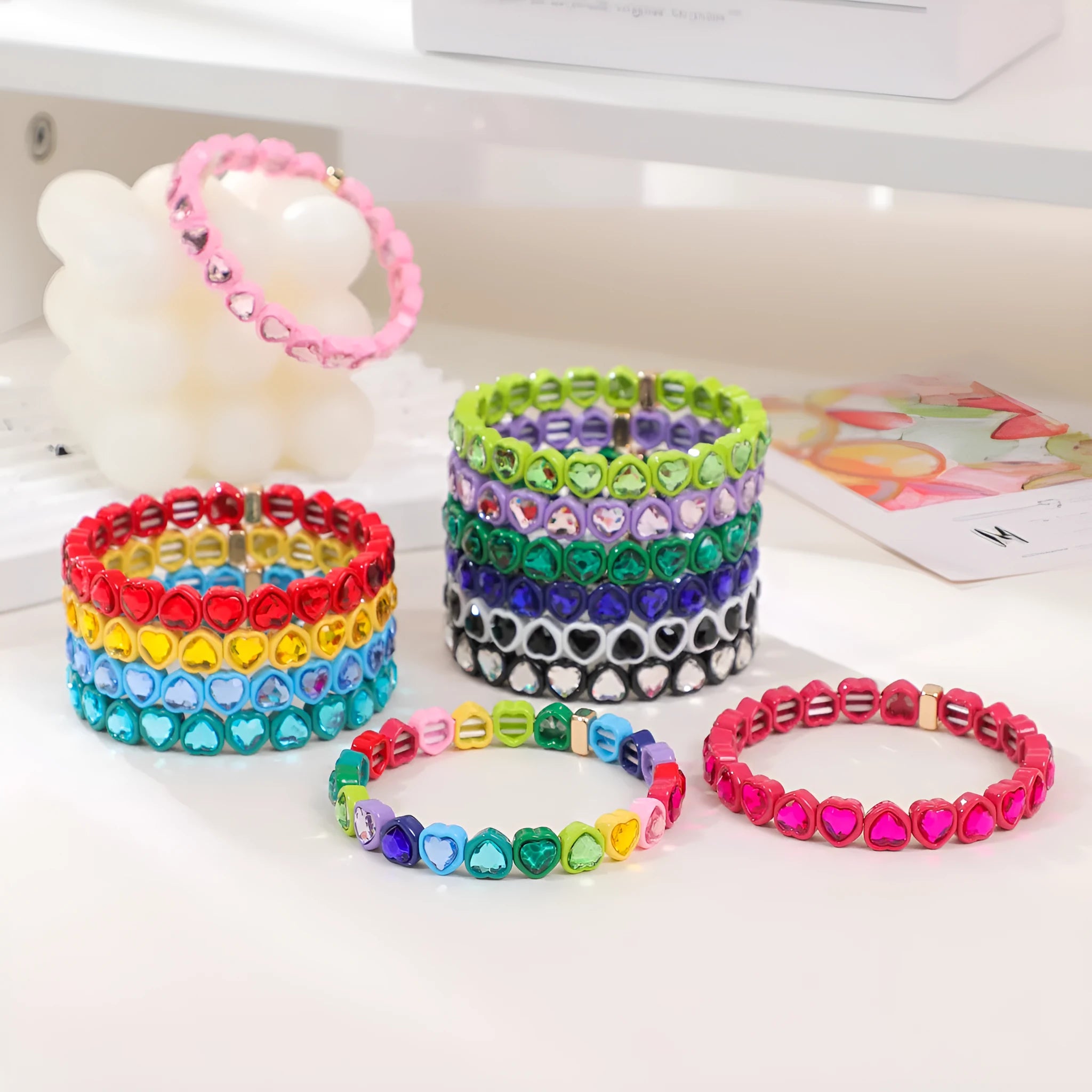 Rainbow enamel heart pendant on a stretch alloy bracelet, shown in multiple colour options.