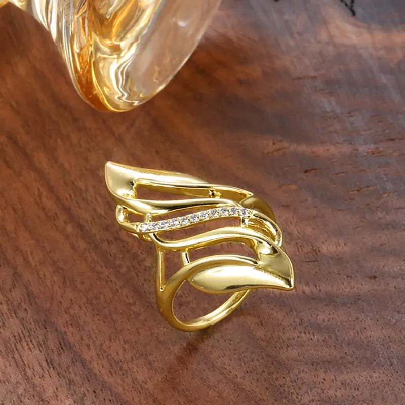 Gold coloured women's ring with exaggerated curved design on copper band