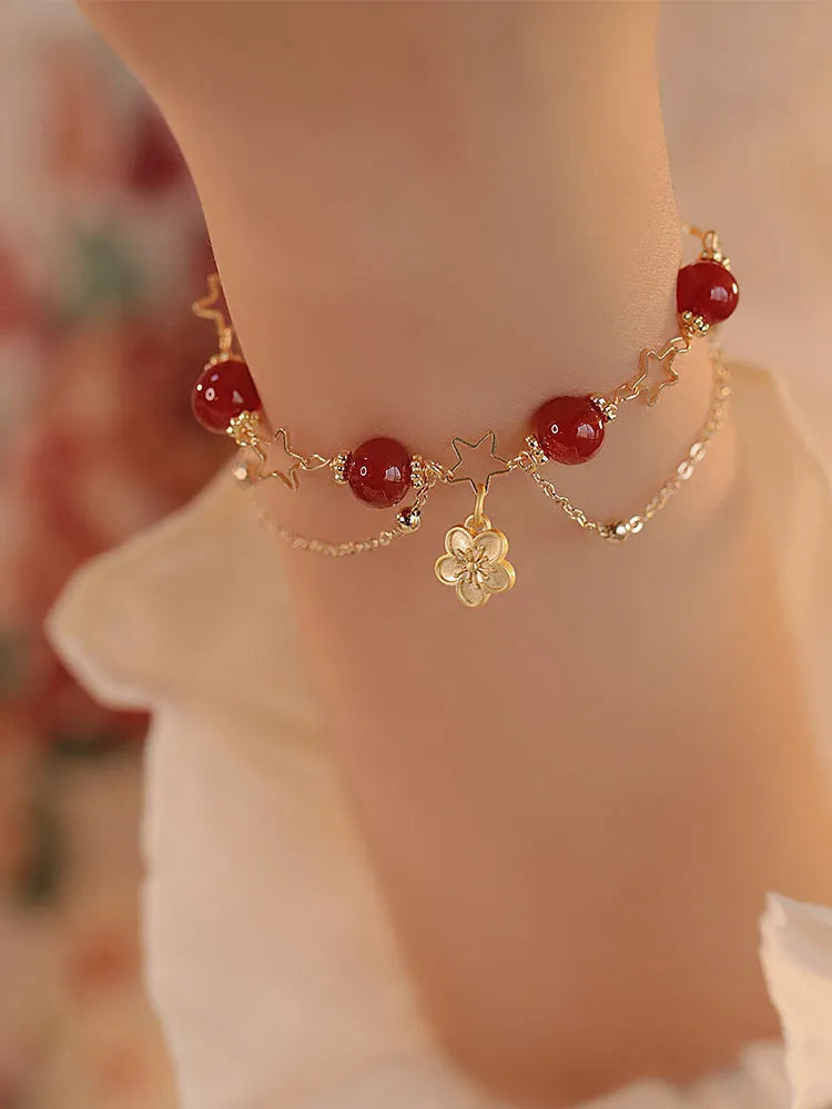 Red agate double layer bracelet with peach blossom floral details on woman's wrist
