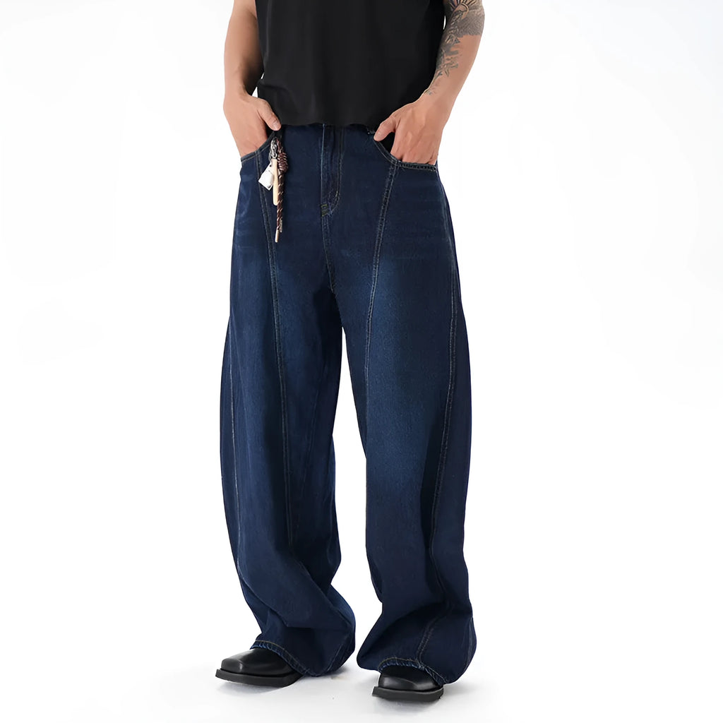 Dark blue wide leg distressed jeans on a hanger showing washed denim fabric and machete cut.