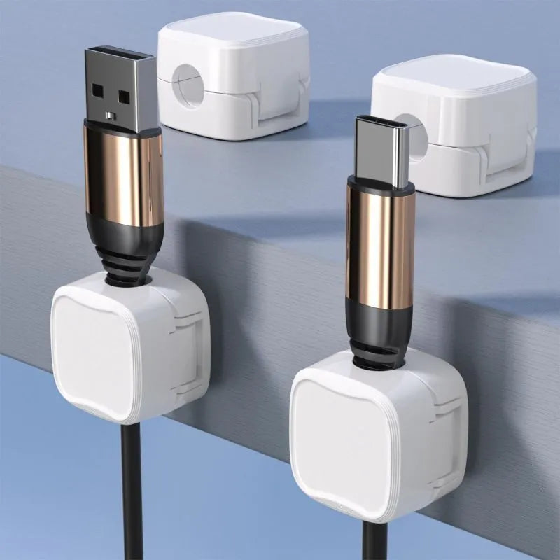 White and black magnetic cable clips with adhesive backing organising multiple cables under a desk