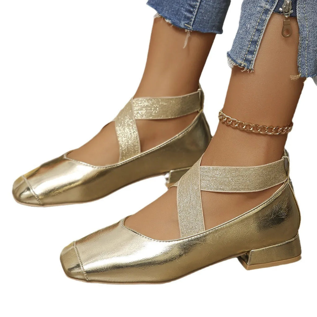 Gold French style slip-on evening pumps with square toe and low heel on a white background