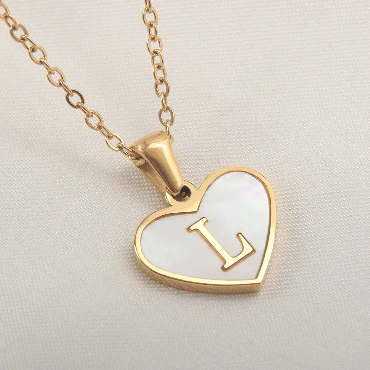 A personalized heart-shaped necklace with a 26-letter charm, crafted from high-quality stainless steel and gold plating.