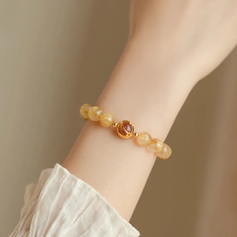 Gold rutilated quartz crystal bracelet with diamond-cut beads in a Korean-style design.