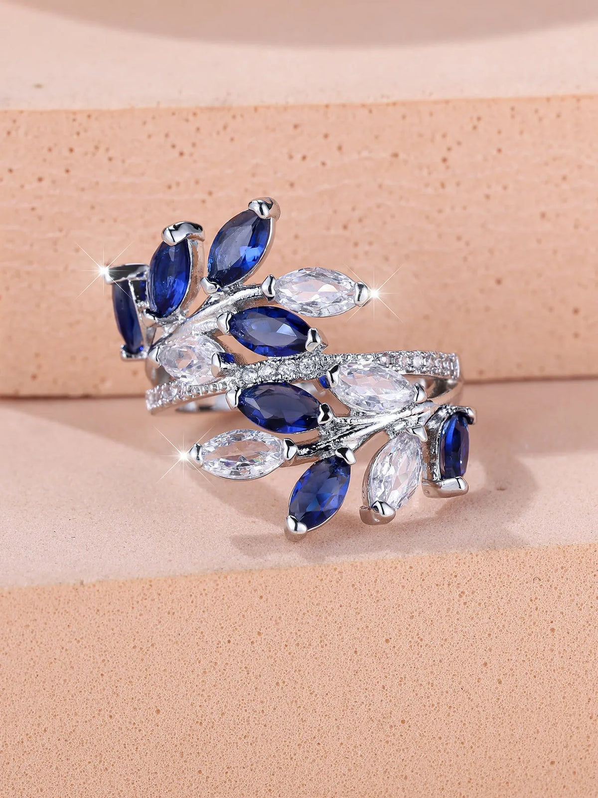 Adjustable copper leaf ring with a horse eye zircon stone in multiple colour finishes on a neutral background.