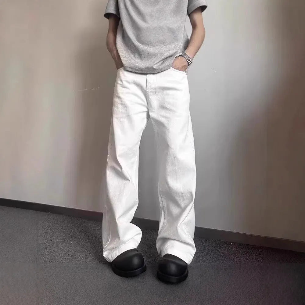 Men's white straight-leg cotton jeans with a wide-leg opening and zipper fly.