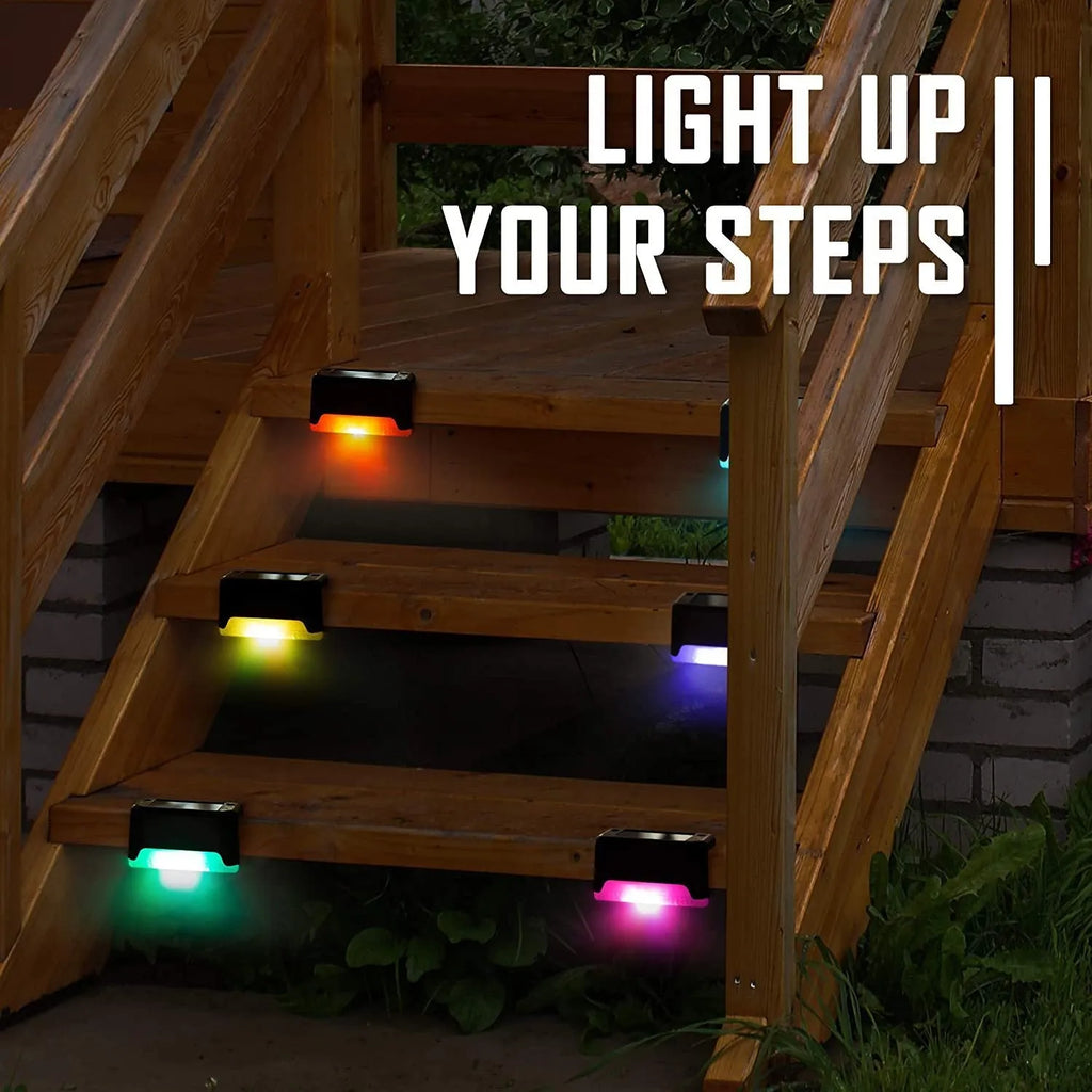 Set of four brown solar step lights with warm LED glow mounted on outdoor wooden stairs