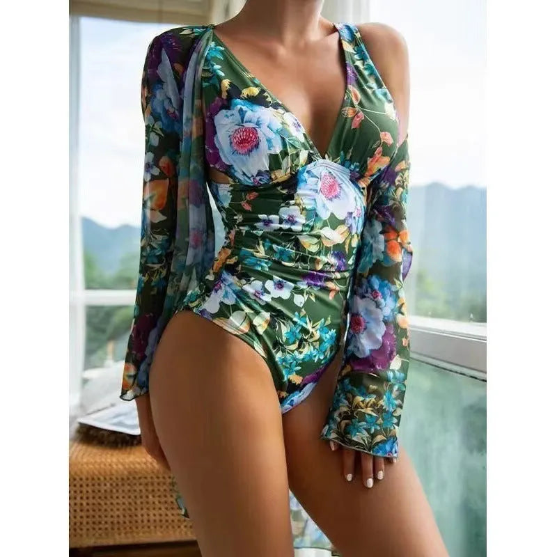 Women's floral print bikini and matching coat three-piece swimsuit set on a hanger.