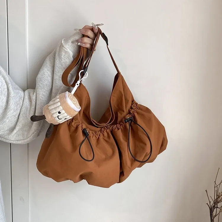 Ultra-light pleated crossbody student cloth bag in folded position showing split pocket design
