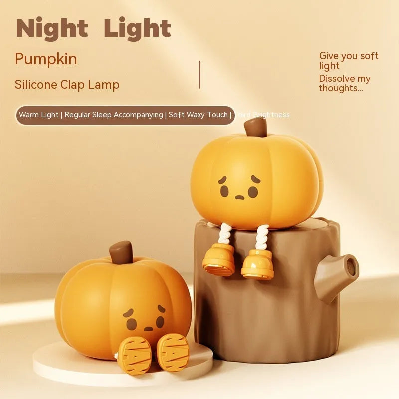 Pumpkin-shaped silicone night light with soft orange glow on wooden bedside table