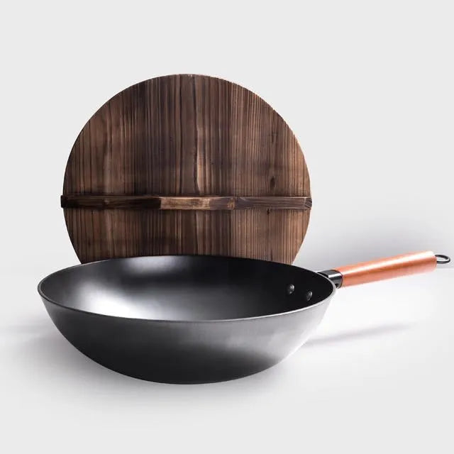 Black traditional iron wok with wooden handle, shown with glass lid.