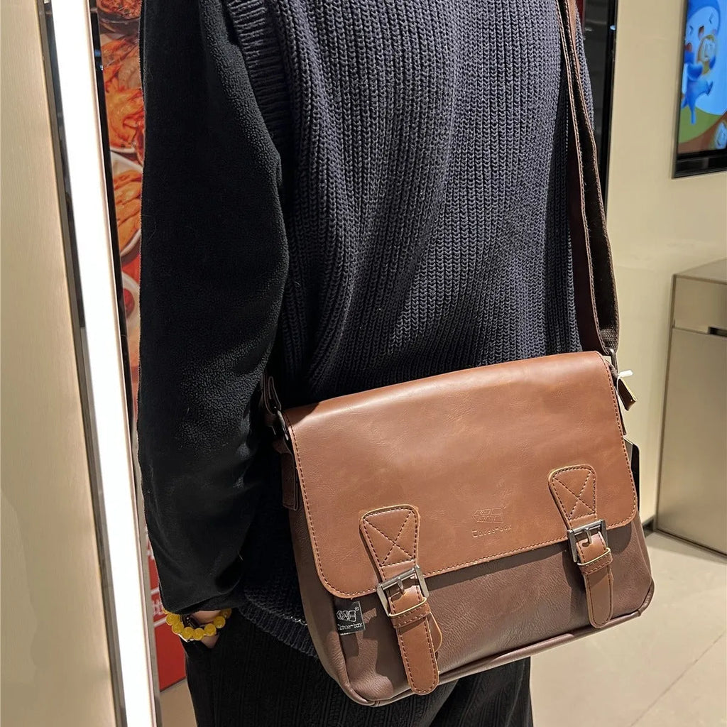 Retro men's messenger bag in light brown PU material with shoulder strap on neutral background