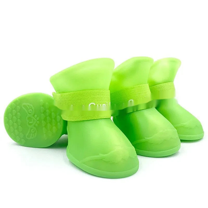Four rubber pet rain shoes in various colours with anti-slip soles for dog paw protection