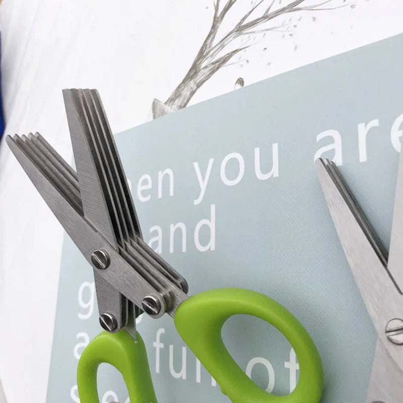 Stainless steel multi-blade kitchen scissors for cutting onions and herbs on a chopping board.