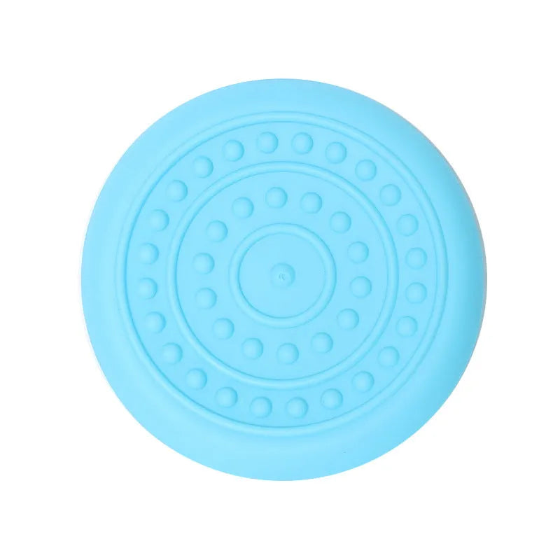 Plastic dog frisbee toy in green, shown on grass for fetch play.
