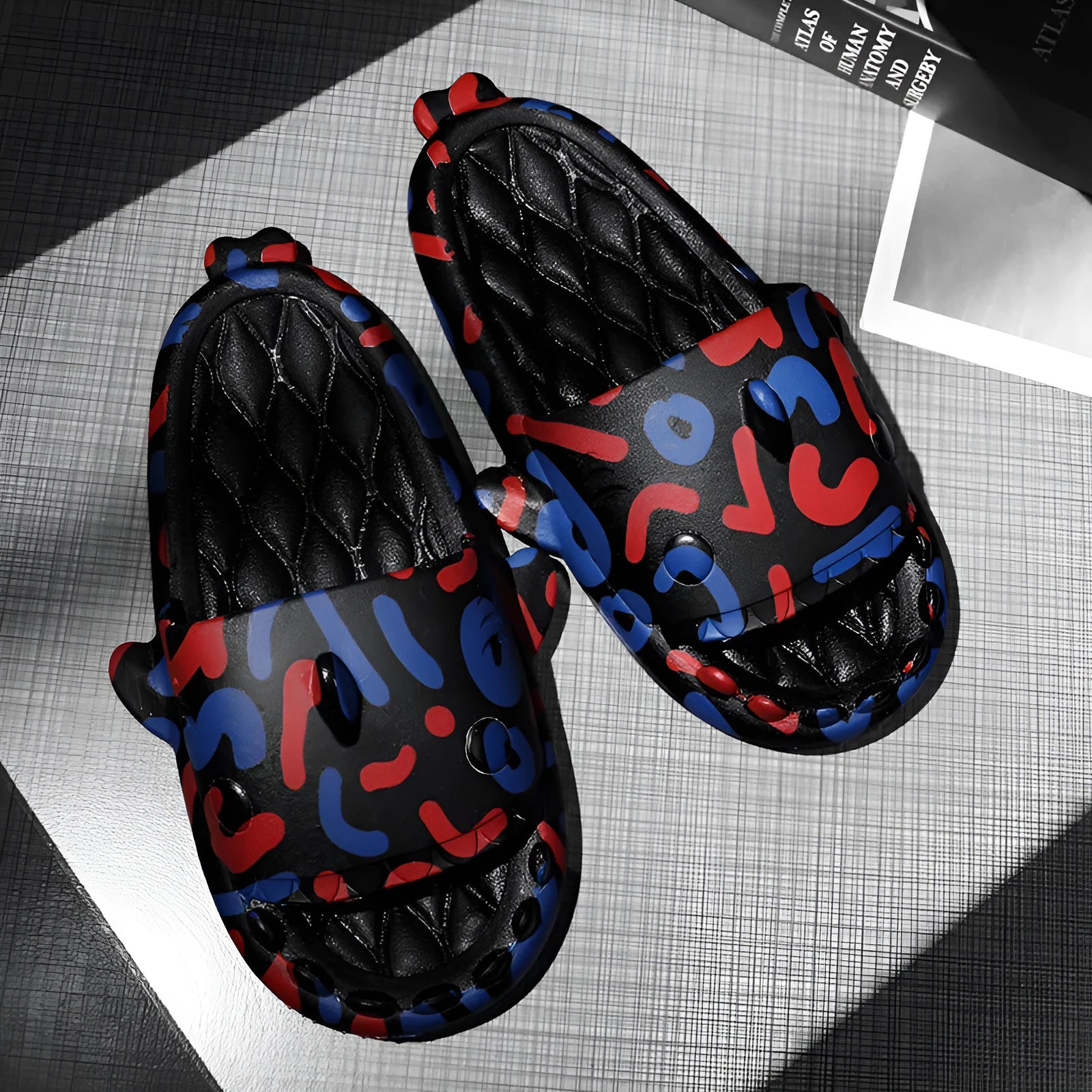 Pair of open-toe EVA slippers with a shark couple design on the footbed.