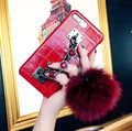 Red PU leather iPhone case with rhinestone studs and a white fox fur ball charm attached.