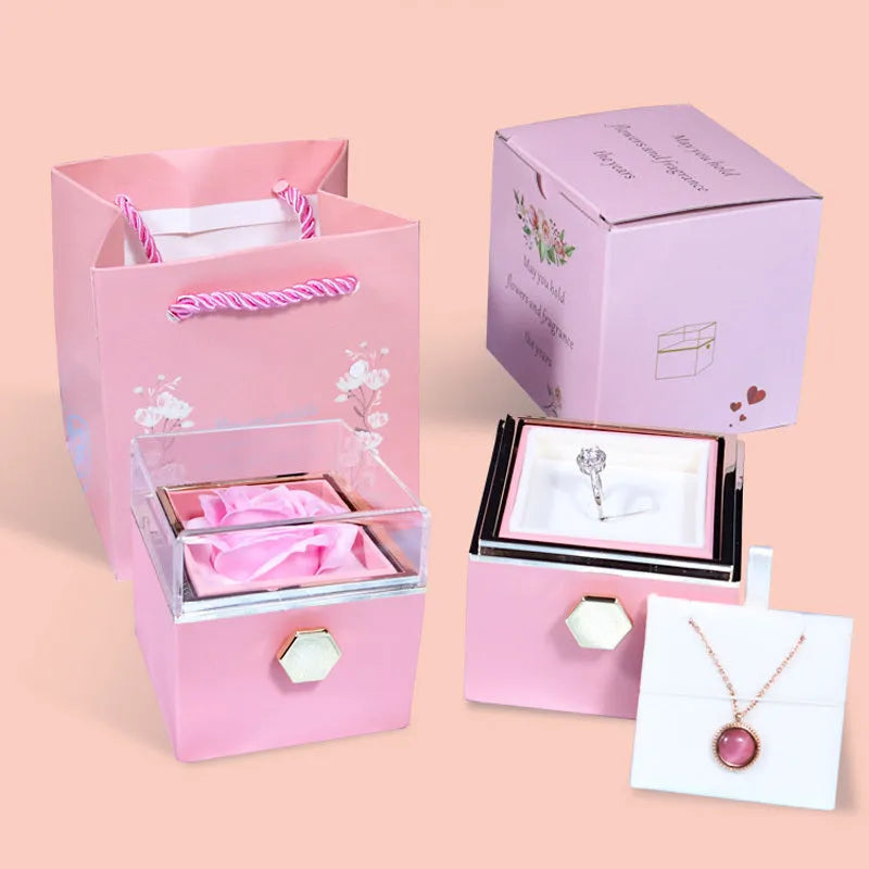 Rotating jewellery box with preserved red rose under acrylic cover and drawer open showing storage