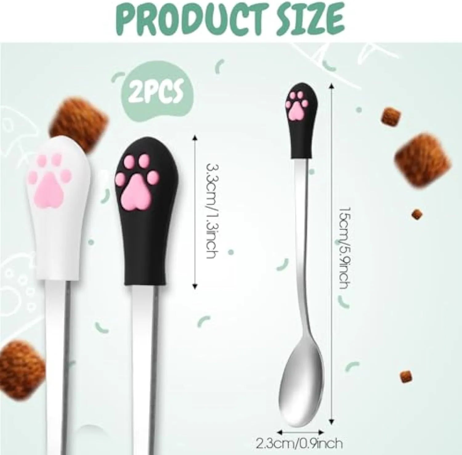 White and black stainless steel pet food spoons with silicone cat paw print handles on a table.