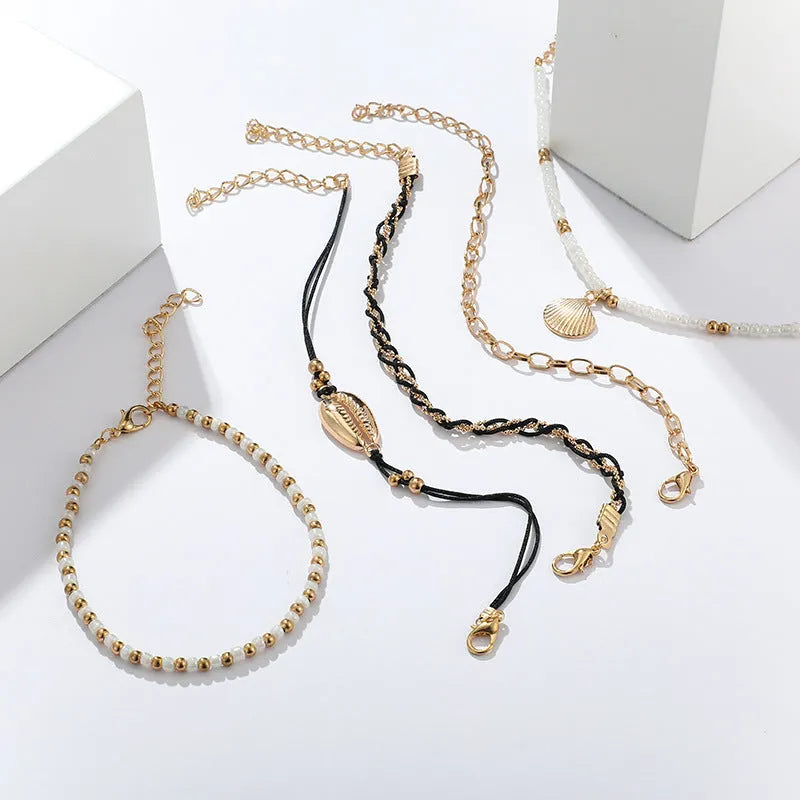 Five-piece gold tone anklet set with braided, shell and geometric ethnic style anklets for women