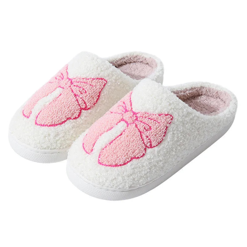 Cotton slippers with cartoon bow knot design on suede upper in pink or blue colours with TPR sole