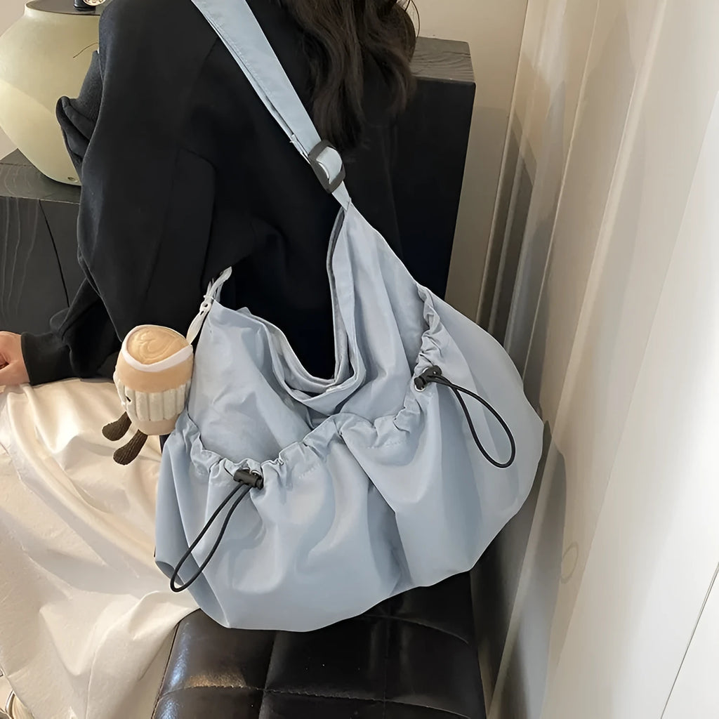 Ultra-light pleated crossbody student cloth bag in folded position showing split pocket design