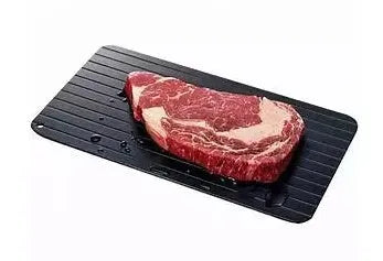 Black aluminium fast defrosting tray for kitchen use on a countertop