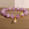 Mauve jade rabbit bracelet with a purplish red jade hare head charm on a crystal band.