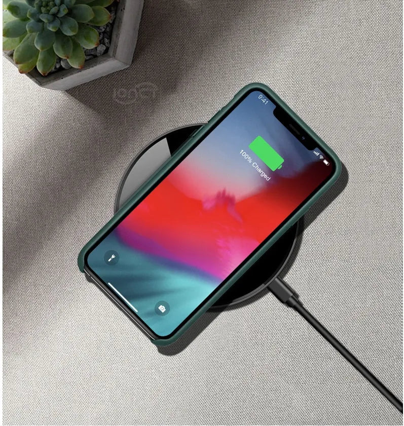 Black QI wireless charging pad with smooth plastic surface and silicone non-slip base