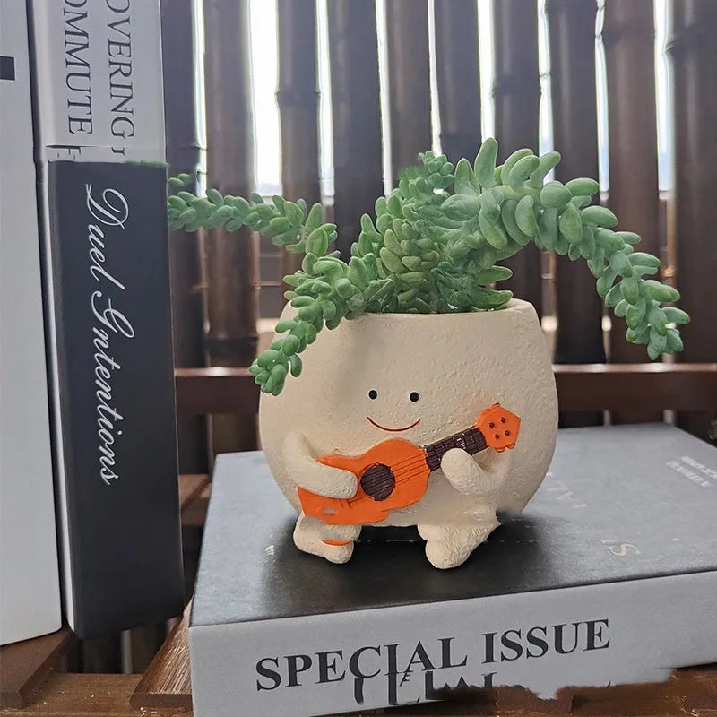Ukulele-shaped resin succulent flower pot in office decoration setting.