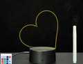 Black 3D acrylic message board lamp with remote control and marker pen on a desk.