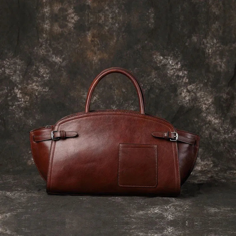 Genuine top grain leather women's crossbody bag in brown with dumpling shape and zip closure.
