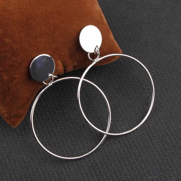 Large circle gold alloy hoop earrings with diamond-cut finish on white background