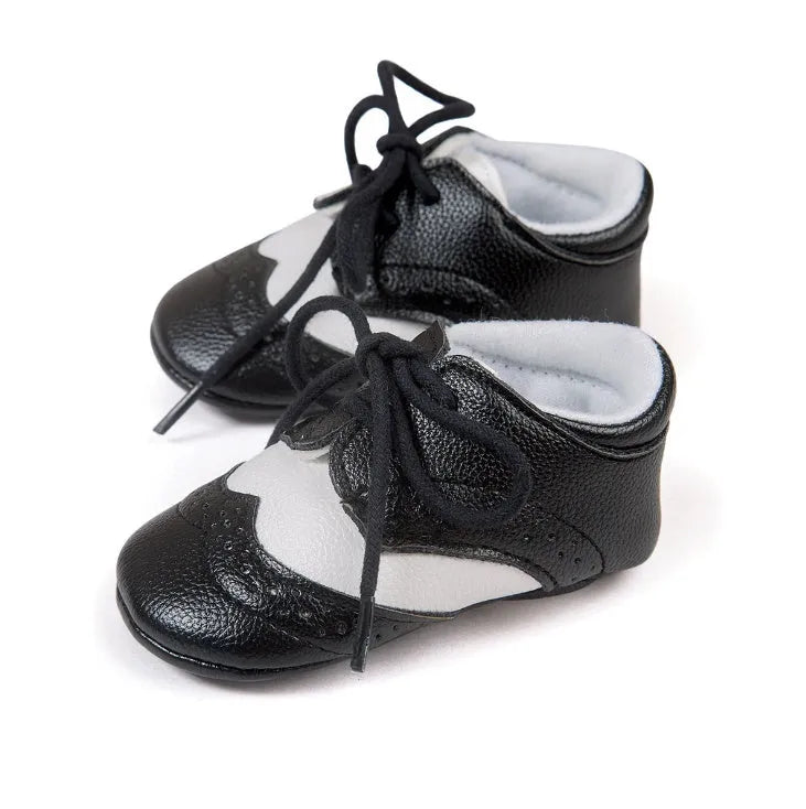 Vintage-style soft-soled baby shoes in synthetic leather, shown in light brown.