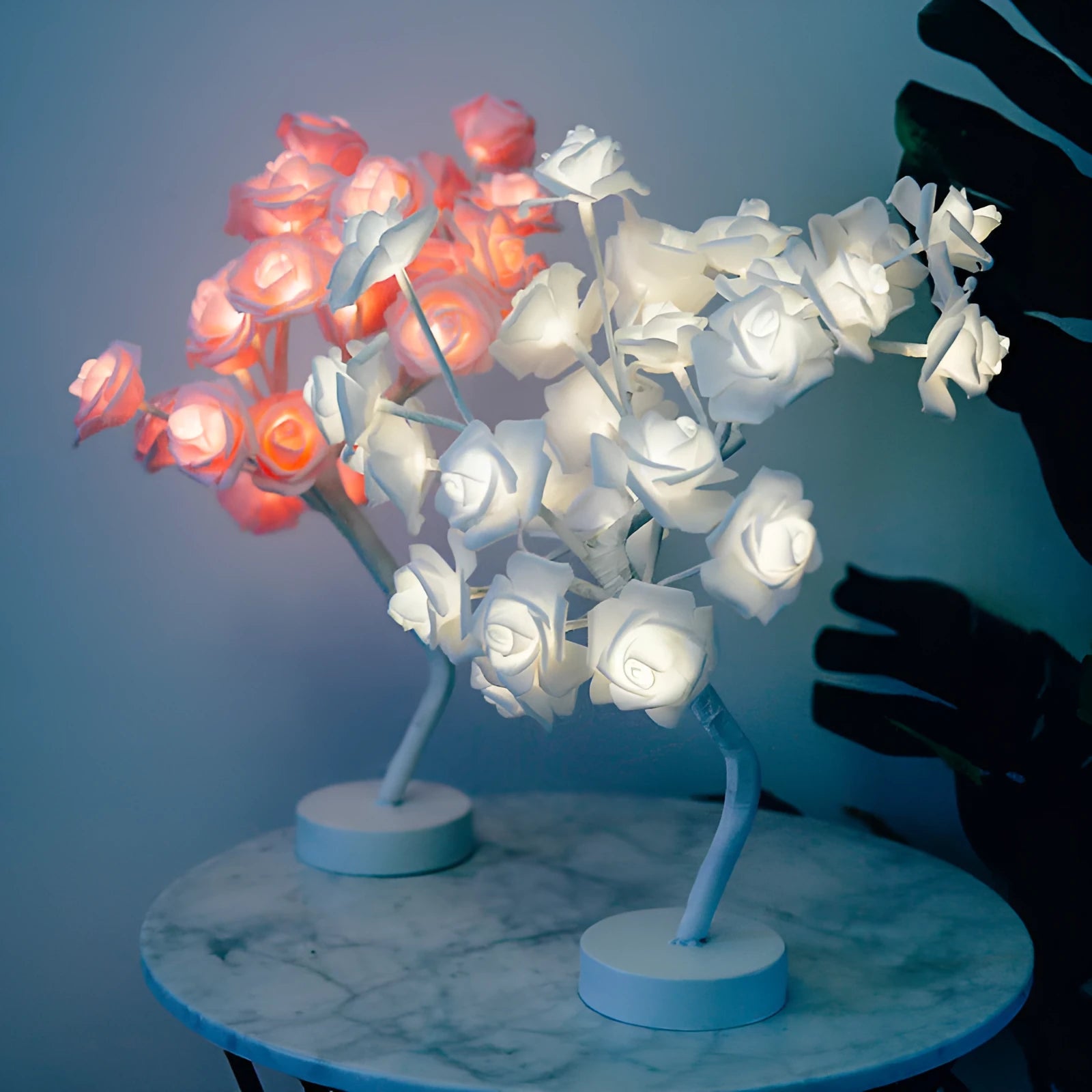 White and red rose flower LED table lamp with bonsai tree and garland lights on a table.