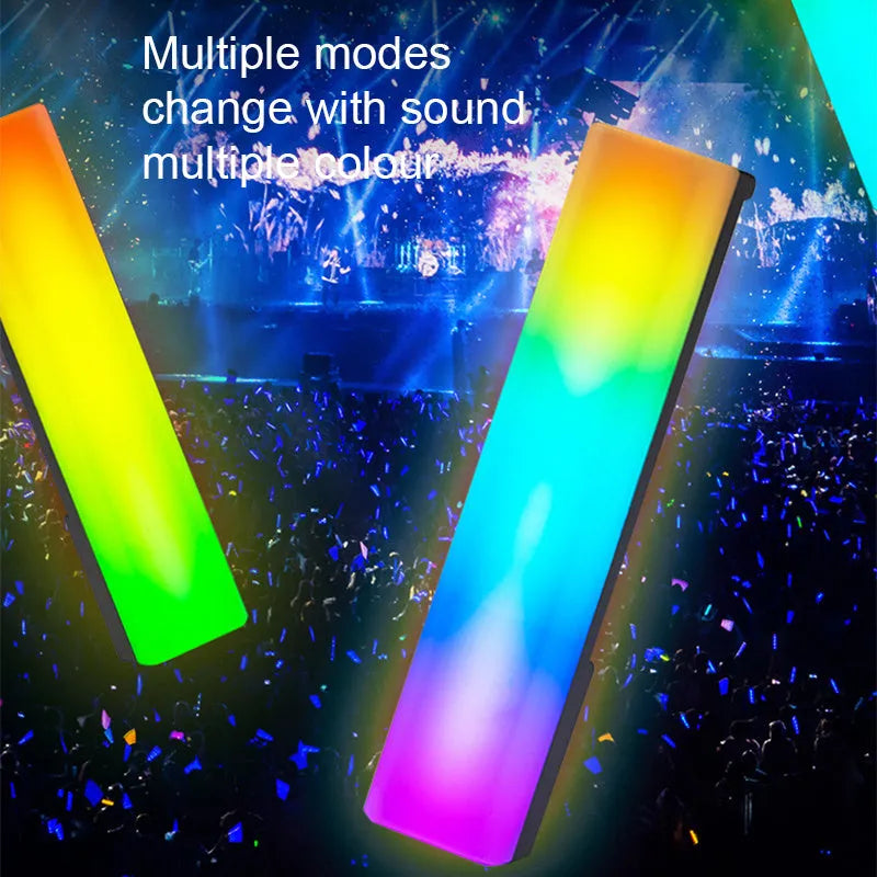 Slender black 3D RGB ambiance lamp with colourful LEDs on a desktop next to a PC monitor.
