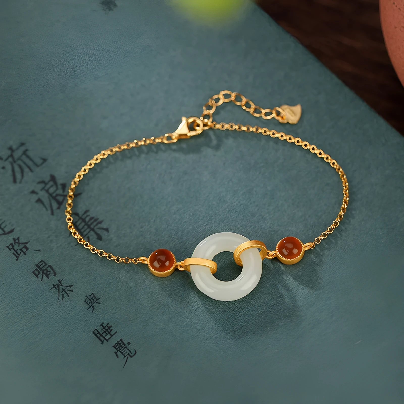 Close-up of a sterling silver bracelet with a gold-plated peace buckle holding inlaid natural Hetian jade.