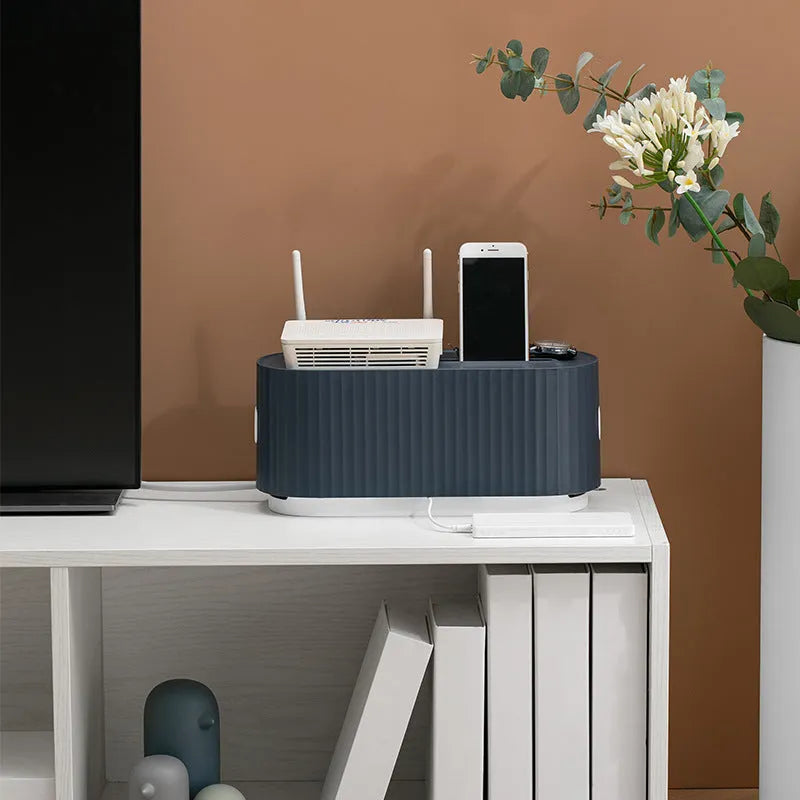 Blue and white HIPS plastic power strip storage box with lid open, showing phone slot and cable holes.