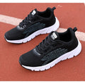 Low-top black and white running sneakers with cross strap design and MD sole
