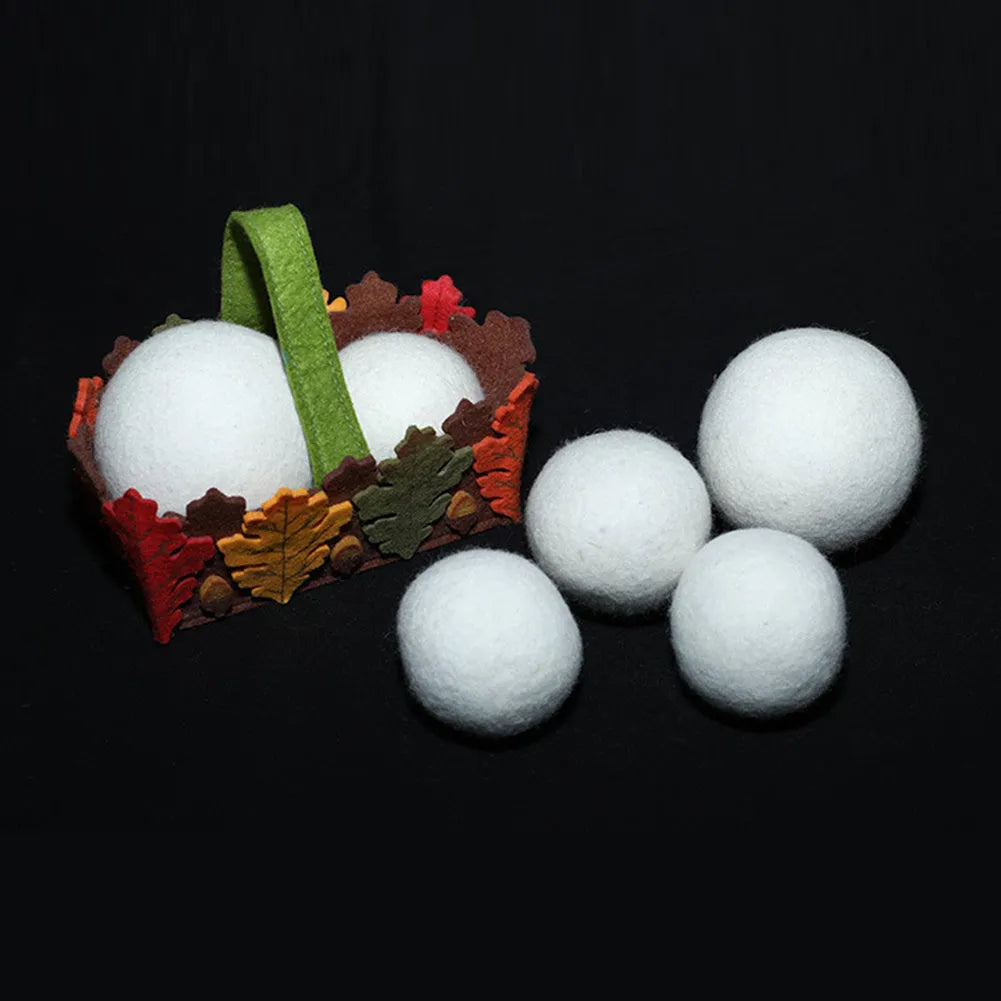A wool drying ball for laundry next to a plain cotton storage bag on a background.