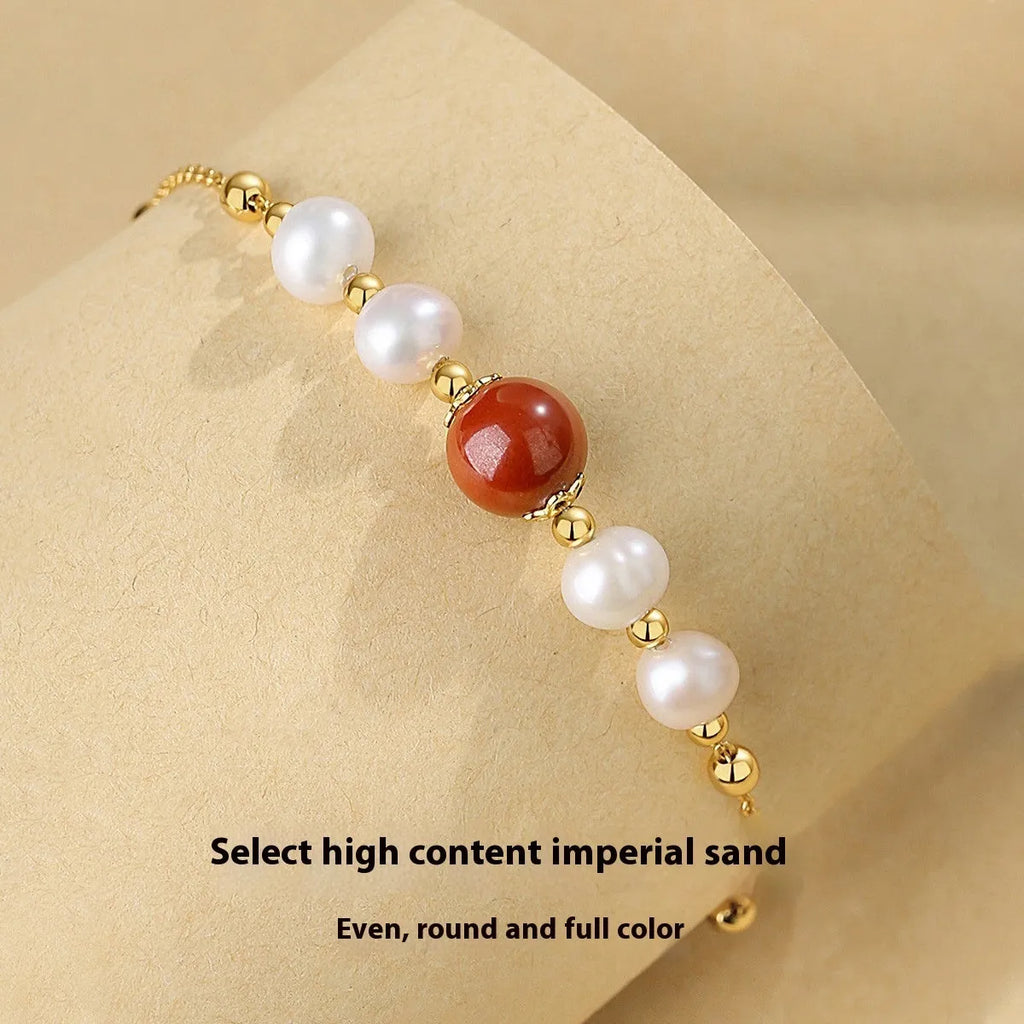 Yellow retro-style bracelet with red cinnabar beads and white pearls on a silver chain.