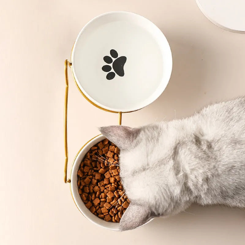 White ceramic cat bowl with cat paw design on a black iron stand
