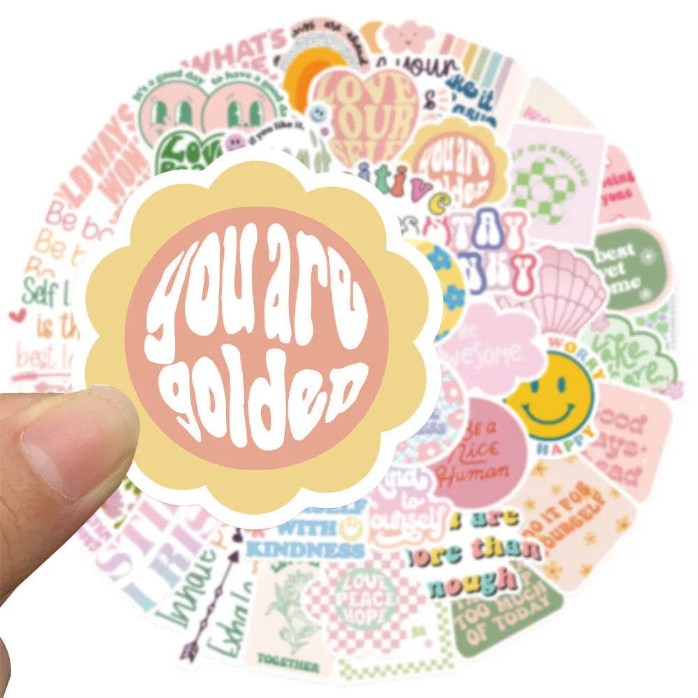 Danish pink motivational statement stickers with graffiti and cartoon designs on a laptop.